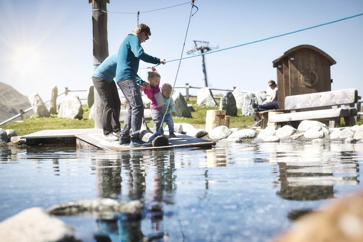 Familie am Wasserspielplatz Mutspuren BP © Arlberger Bergbahnen BP